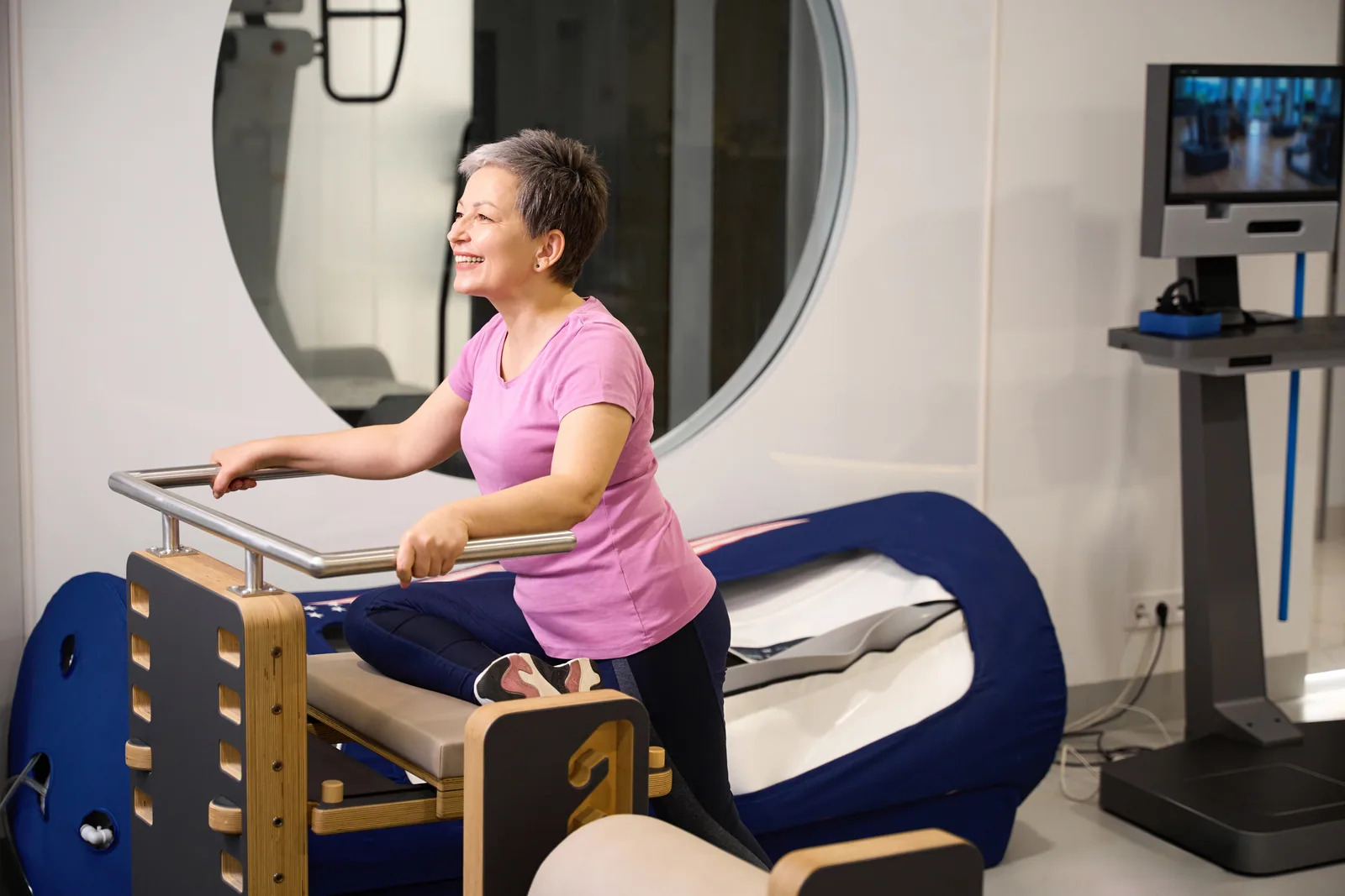 A patient working on a reformer for guided pain-relief exercise